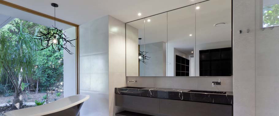 Mirror above sink in bathroom with glass wall